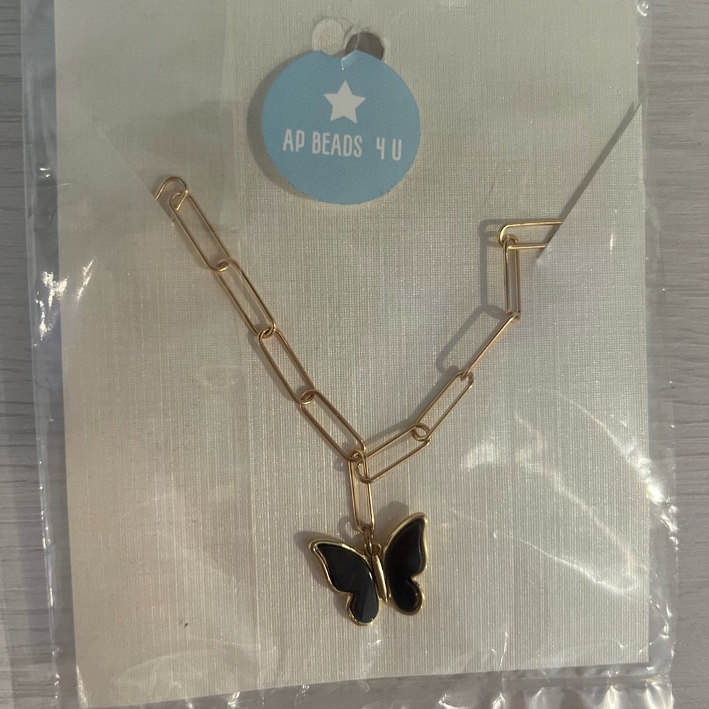 Gold paper lip chain with black butterfly charm. Brand new